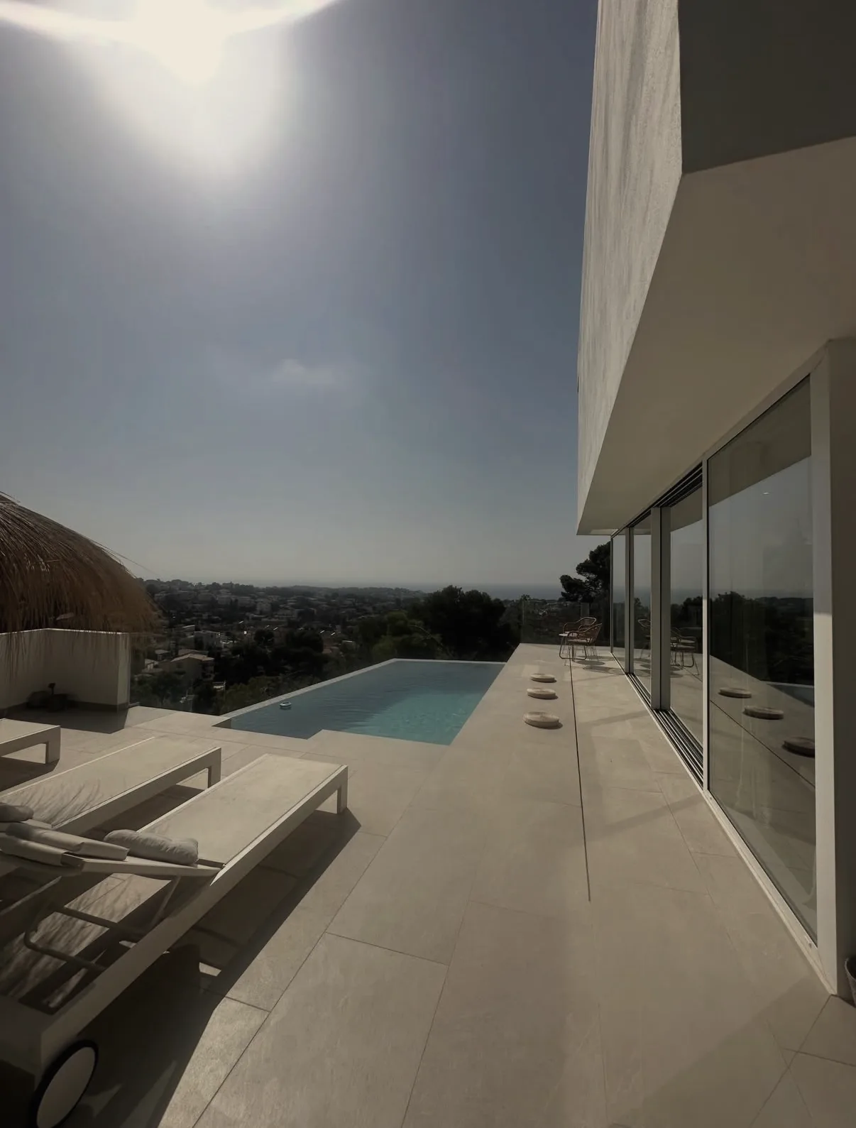 Terrasse mit Infinity-Pool und Liegen vor weitem Ausblick